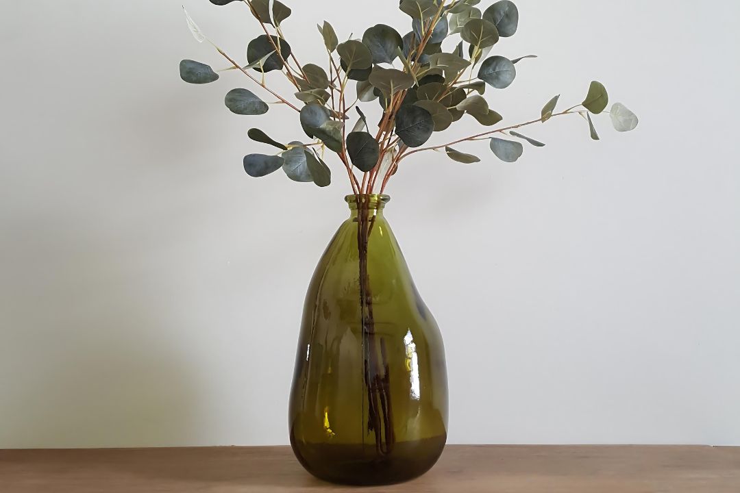 vases on a table with faux eucalyptus leaves
